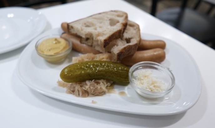 Sauerkraut with sausages, bread, gherkin and sauce